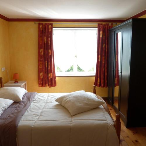 une chambre avec un lit et une grande fenêtre dans l'établissement Gîte de la Chenardais, à La Boussac