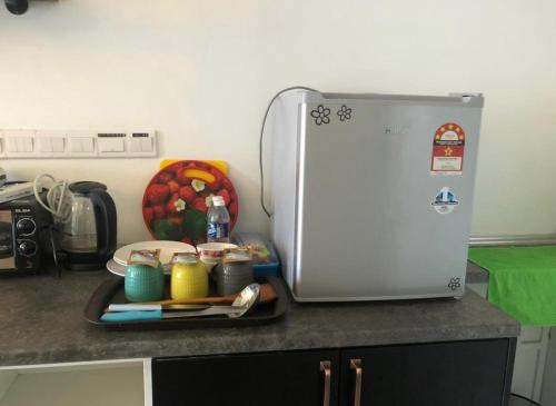 a kitchen counter with a tray of food next to a refrigerator at Aeropod 5 mins to Airport 10 mins to KK city in Kota Kinabalu