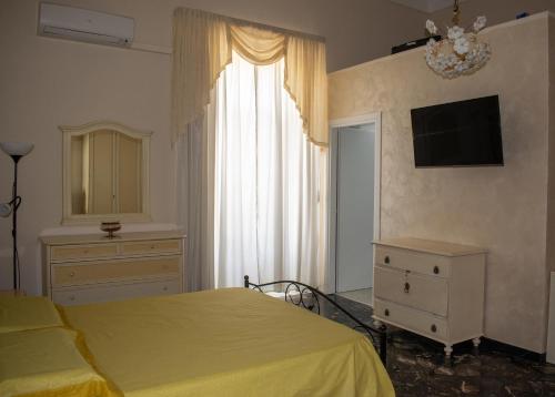 a bedroom with a bed and a dresser and a window at Palazzo San Francesco in Scorrano