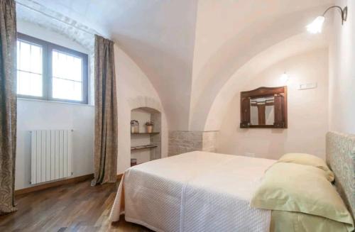 - une chambre avec un grand lit et une fenêtre dans l'établissement Madre Terra, à Toritto