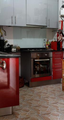 a kitchen with a stove and red cabinets at Casa Margou in São Pedro do Sul