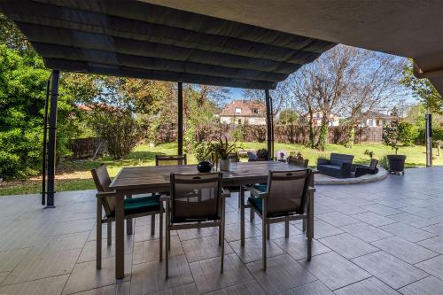 d'une terrasse avec une table et des chaises en bois. dans l'établissement Maison Familiale BERGERAC billard jardin clos, à Bergerac