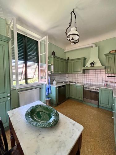 a kitchen with green cabinets and a wooden table at San Romano centro storico in Lucca