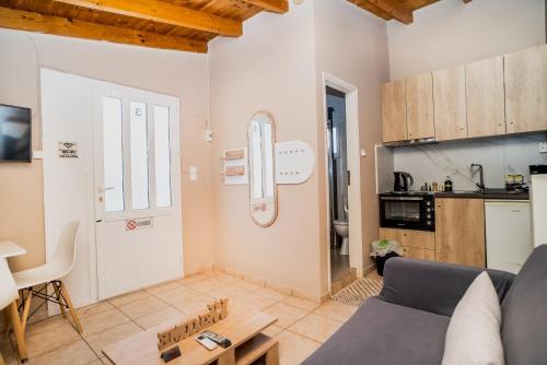 a living room with a couch and a kitchen at The DreamHouse Athens Airport in Artemida