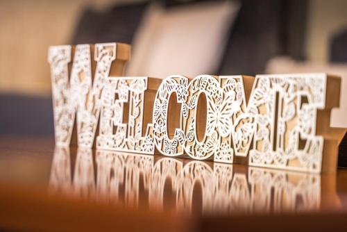 a wooden block with the word wisdom spelled out in white at The DreamHouse Athens Airport in Artemida