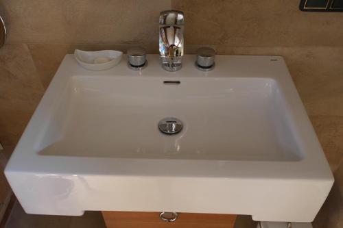 a white sink with two cups on top of it at Presshaus Alte Mühle in Stainz