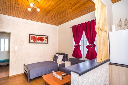 a living room with red curtains and a couch at The DreamHouse Athens Airport in Artemida