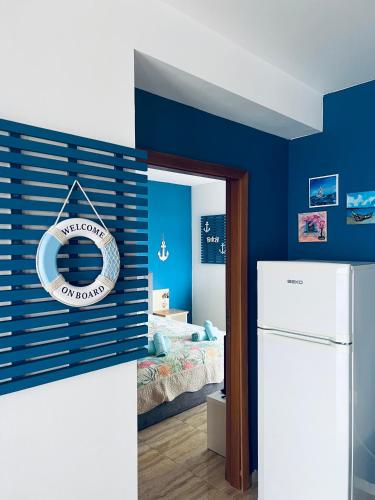 a blue room with a refrigerator and a bedroom at La terrace Sea view in Sveti Vlas