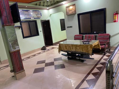 Safari Hotel في Dera Ghāzi Khān: لوبي مع طاولة وكراسي في غرفة