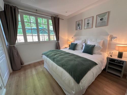 une chambre avec un grand lit et une fenêtre dans l'établissement Villa Elisabeth, à Versailles