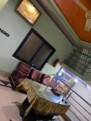 a living room with a television and a table with a chair at Safari Hotel in Dera Ghāzi Khān