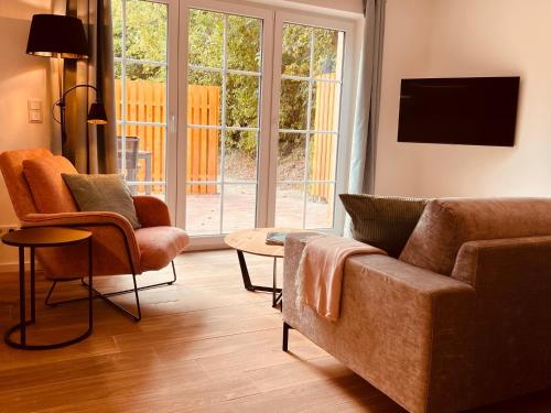 ein Wohnzimmer mit einem Sofa und 2 Stühlen in der Unterkunft Sommerhaus 54, Gartenhaus "S" in Grödersby
