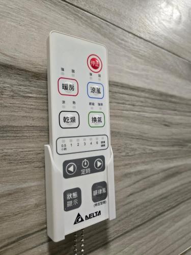 a remote control sitting on top of a wooden table at 眠極文旅-無人化民宿 臺東縣民宿2110號 in Taitung City