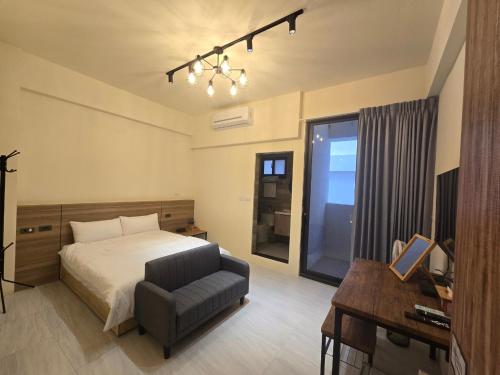 a bedroom with a bed and a chair and a desk at 眠極文旅-無人化民宿 臺東縣民宿2110號 in Taitung City