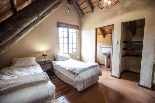 a attic room with two beds and a window at Top Lodge 4x4 Required in Bonjaneni