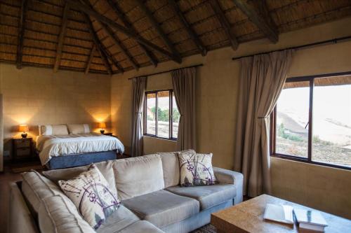ein Wohnzimmer mit einem Sofa und einem Bett in der Unterkunft Top Lodge in Bonjaneni