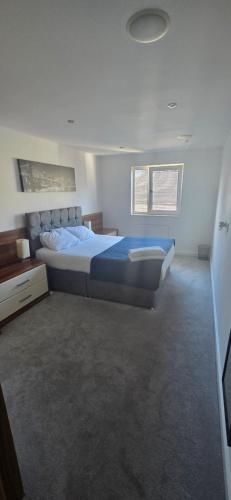 a bedroom with a large bed and two windows at Hullidays - The Sawmill Suite in Hull