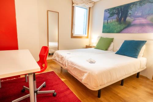 扎馬亞的住宿－Ondartxo II - ONGI ETORRI，一间卧室配有一张床、一张桌子和一张桌子