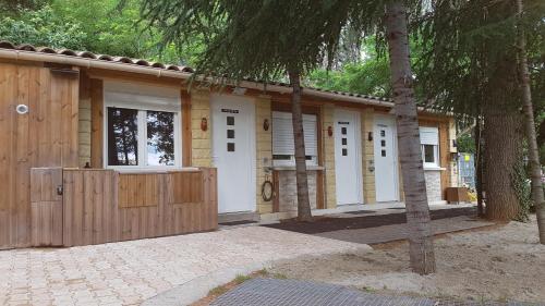 une maison avec des portes blanches et une clôture dans l'établissement Paisible Chalet, à Largentière
