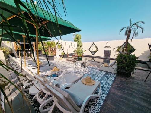 - un ensemble de chaises et de tables sur une terrasse dans l'établissement Palais-Riad Razala & Spa, à Marrakech