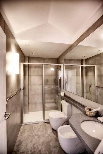 a bathroom with a shower and a toilet and a sink at Apartamentos Áncora in Barro de Llanes