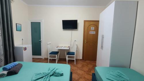 a bedroom with two beds and a desk and a door at Guest House Tian & Hojz in Durrës