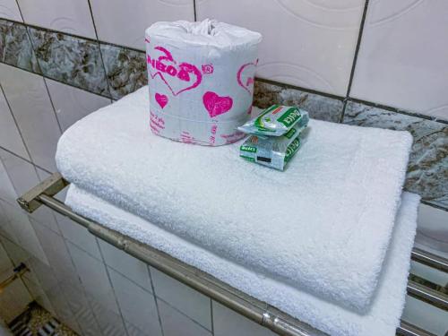 een stapel handdoeken op een plank in een badkamer bij ROCK CASTLE FURNISHED APARTMENTS in Limbe