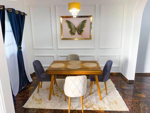 une salle à manger avec une table en bois et des chaises bleues dans l'établissement ROCK CASTLE FURNISHED APARTMENTS, à Limbe