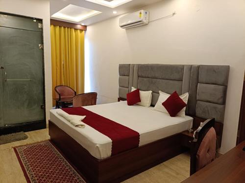 um quarto com uma cama com almofadas vermelhas em Hotel Grand Maurya em Siwān