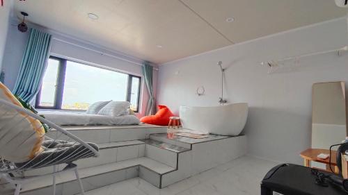 a bathroom with a bed and a tub and a window at Long Vĩ hotel - đảo Phú Quý in Cu Lao Thu