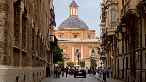 a group of people walking down a street with a building at Valencia Veneta Calda in Valencia