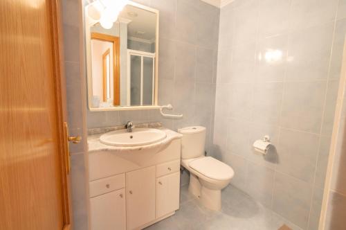 y baño con aseo, lavabo y espejo. en Bonbillo - ONGI ETORRI, en Zumaia