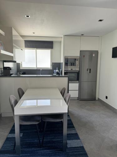 une cuisine avec une table, des chaises et un réfrigérateur dans l'établissement 3 pièces avec vue mer à 5 min de la gare et 10 min du centre, à Beausoleil