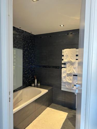 une salle de bain avec une baignoire et un miroir dans l'établissement 3 pièces avec vue mer à 5 min de la gare et 10 min du centre, à Beausoleil