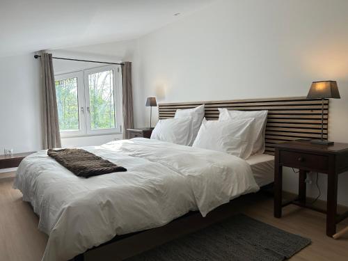 une chambre avec un grand lit blanc avec une fenêtre dans l'établissement Gîte du manège - Domainepona, à Croissy-Beaubourg