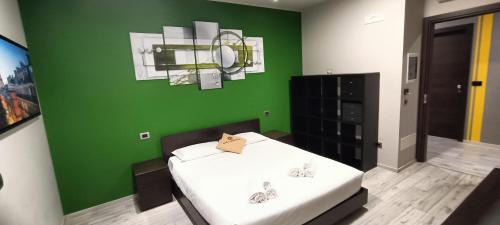 una camera con una parete verde e un letto. di Millaenya Inn a Entratico