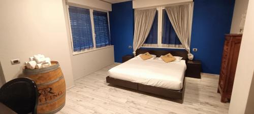 a bedroom with a bed with blue walls and windows at Millaenya Inn in Entratico