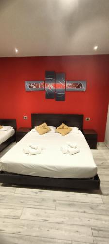a bedroom with a bed with a red wall at Millaenya Inn in Entratico