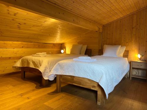 - une chambre avec un lit dans une cabane en bois dans l'établissement Cozy Apartment With Stunning View, à Gsteig