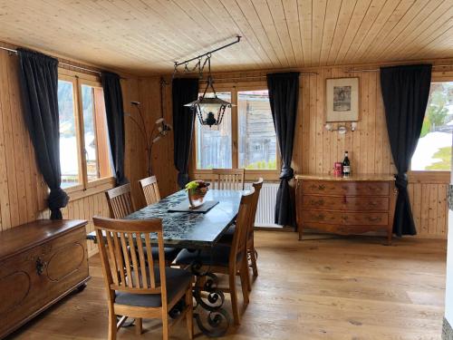 - une salle à manger avec une table et des chaises en bois dans l'établissement Cozy Apartment With Stunning View, à Gsteig