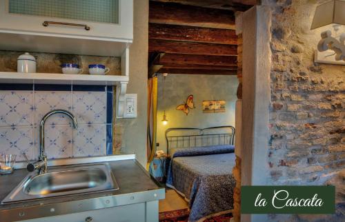 una cocina con fregadero y una cama en una habitación en Il Borghetto Vacanze nei Mulini, en Valeggio sul Mincio