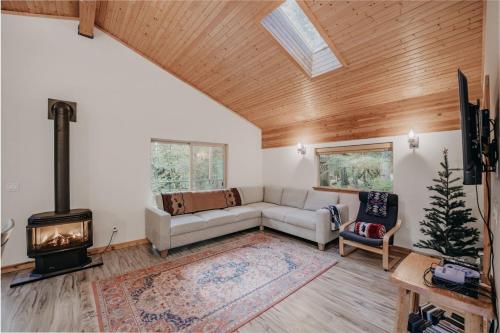 a living room with a couch and a stove at 60GS - Pets OK - Soaker Tub - Deck cabin in Glacier