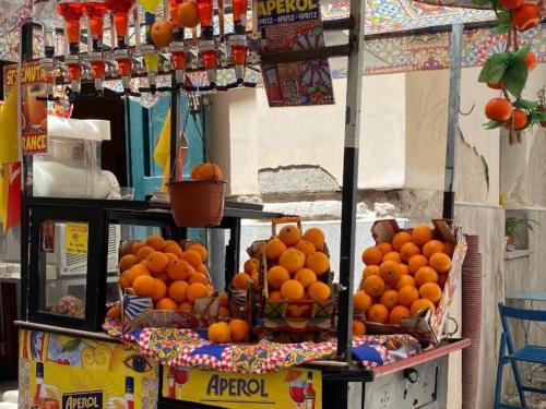 a pile of oranges on a stand on a street at Sea sicily home in Santa Flavia