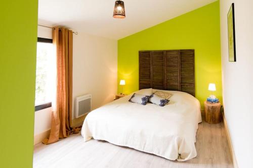 - une chambre avec des murs verts et un lit blanc dans l'établissement Maison aux portes du marais, à Courçon