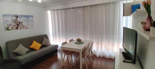 uma sala de estar com um sofá e uma pequena mesa em Casa TARA em Santa Pola