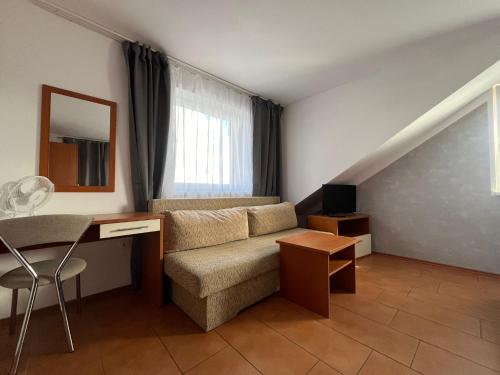 a living room with a couch and a desk at Penzion Relax Martina in České Budějovice