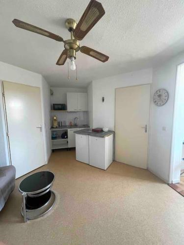 Il comprend un salon avec un ventilateur de plafond et une cuisine. dans l'établissement Appartement Port Leucate, à Leucate