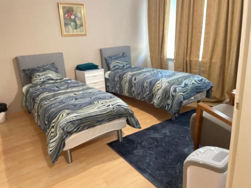 1 dormitorio con 2 camas y alfombra en 2-Bedroom Apartment in Heart of City Center en Turku