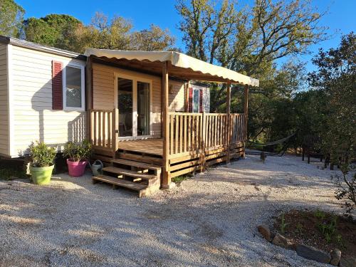 une petite cabine avec une terrasse couverte et une terrasse dans l'établissement Bungalow 4 personnes sur sur propriété privée au calme à 10 mn des plages de Sainte Maxime, à Sainte-Maxime