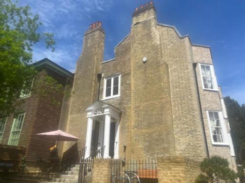 a large brick building with two towers at Croft House Apartments in Hastings